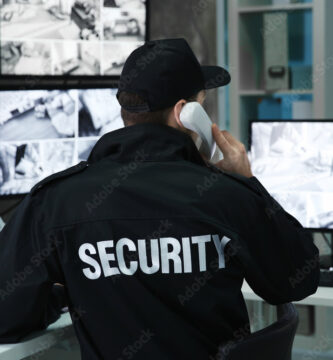 Male security guard talking by telephone in surveillance room